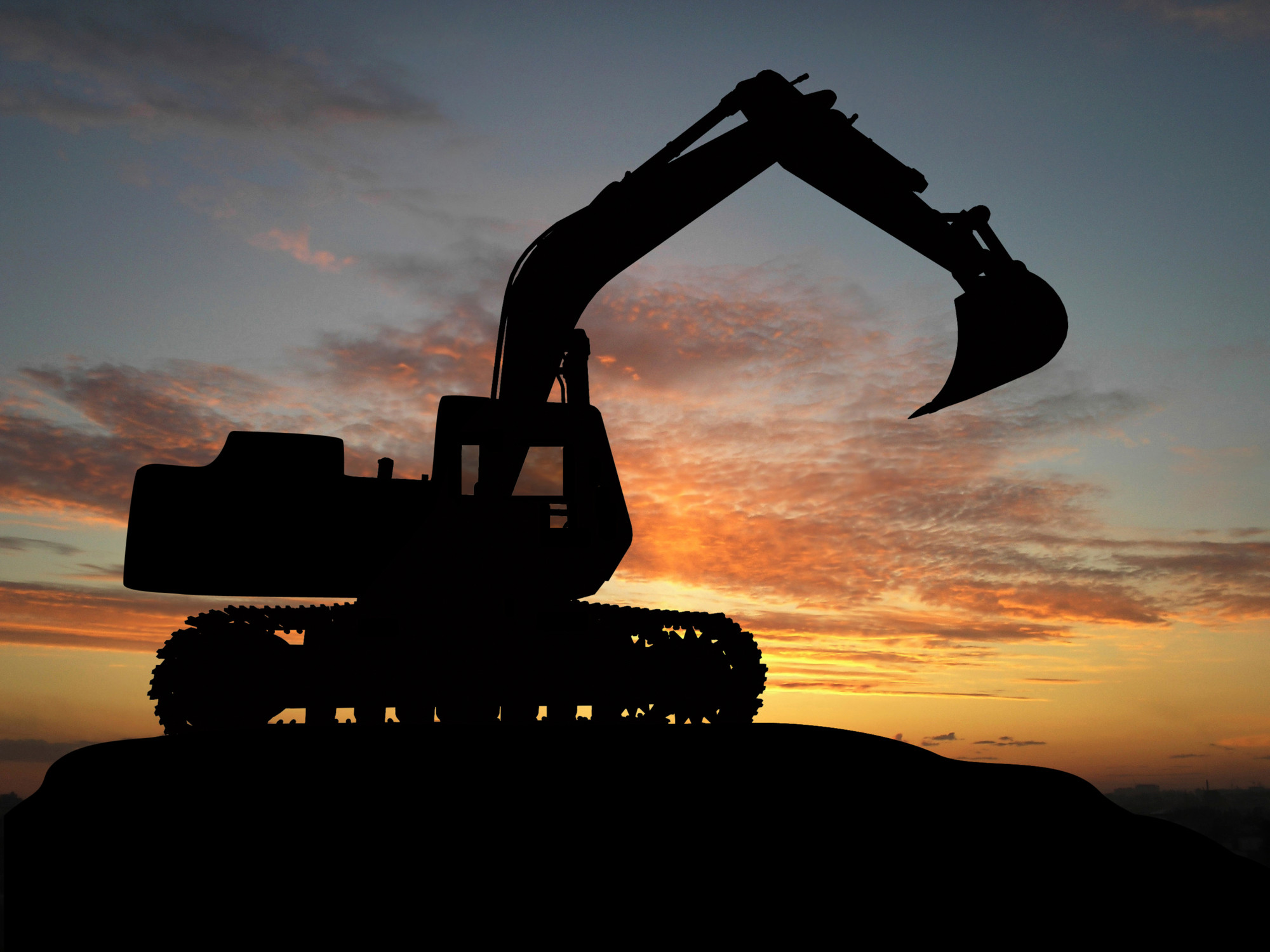 Excavator silhouetted against a Texas sunset